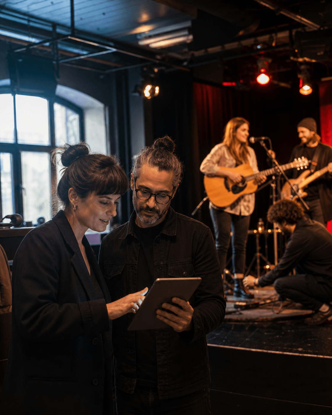 Musiker auf einer Bühne und zwei Menschen bei der professionellen Abstimmung